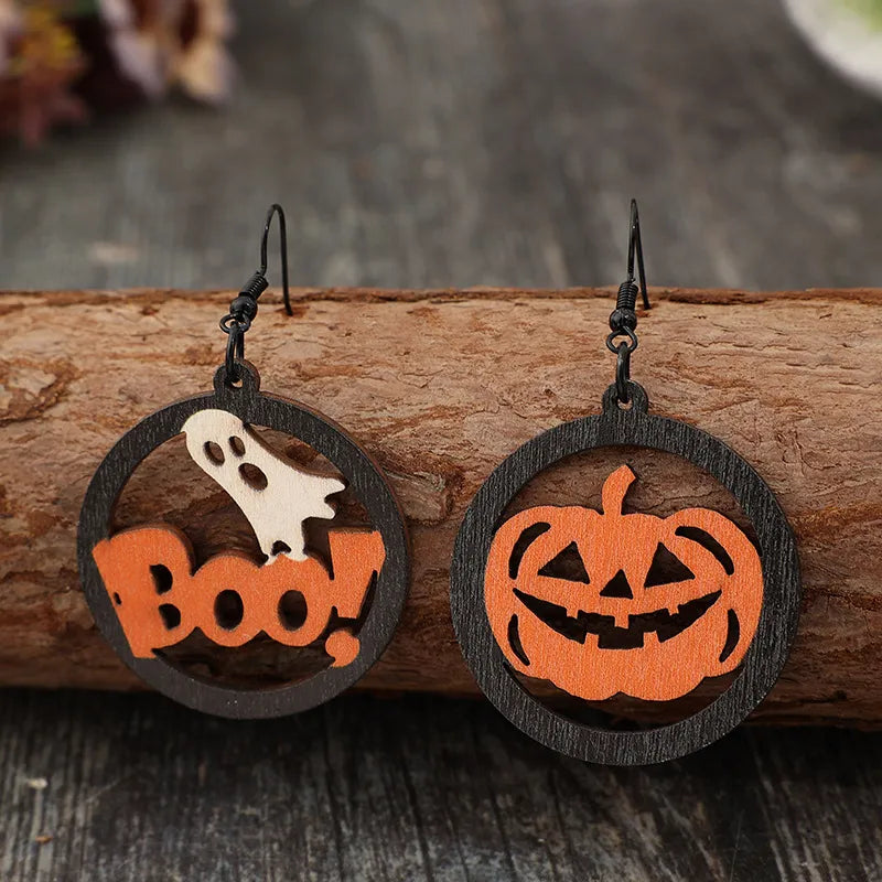 Hollow pumpkin and letter wooden earrings with a ghost and "Boo!" design.
