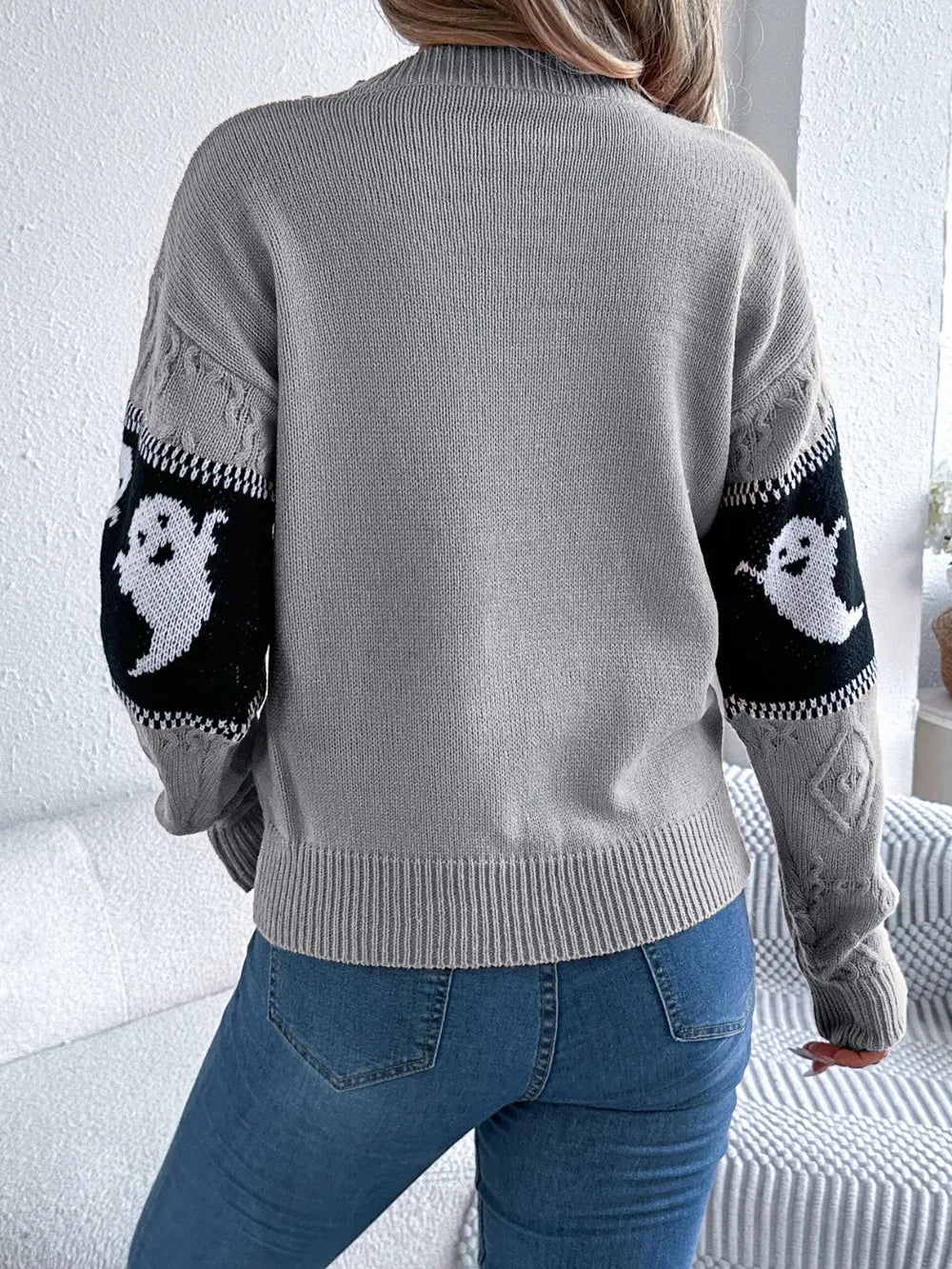 Gray long-sleeve sweater with black and white ghost designs on the sleeves.