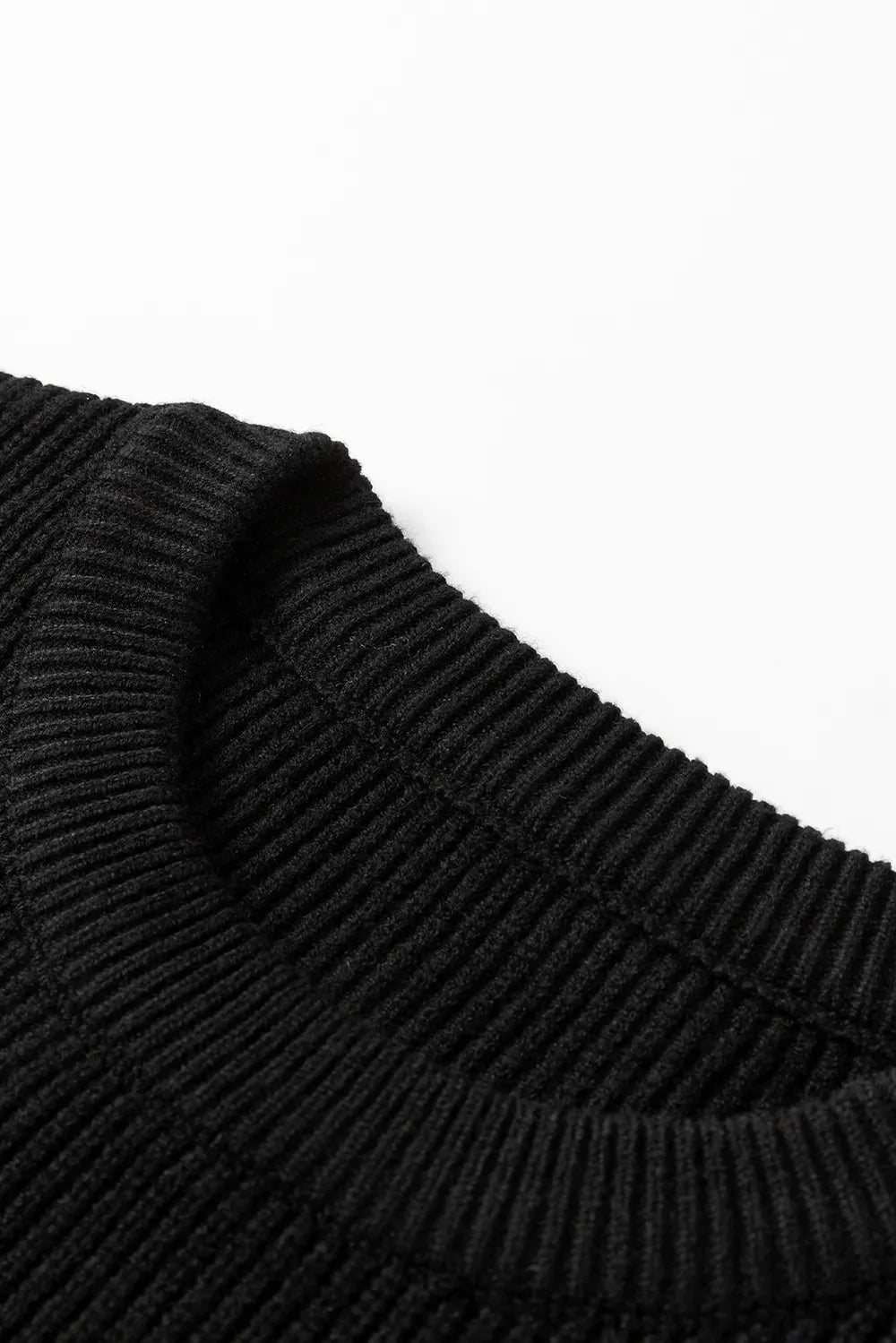 Close-up of a black ribbed knit sweater with a round neck.