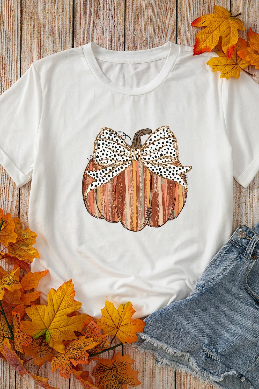 White short-sleeve t-shirt with a pumpkin graphic and leopard print bow.