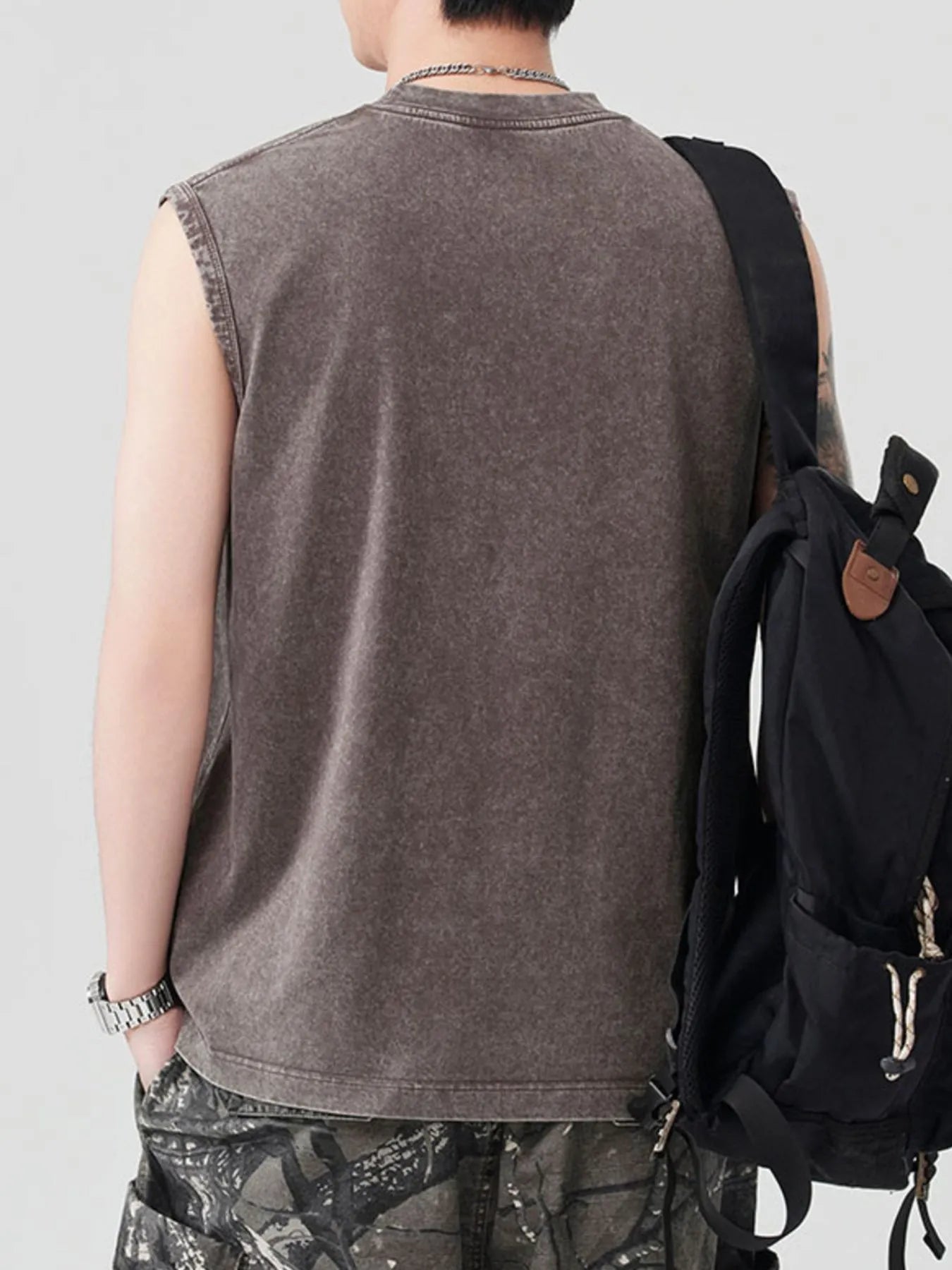 Men's Spider Round Neck Tank in a washed dark gray, worn with a black backpack.