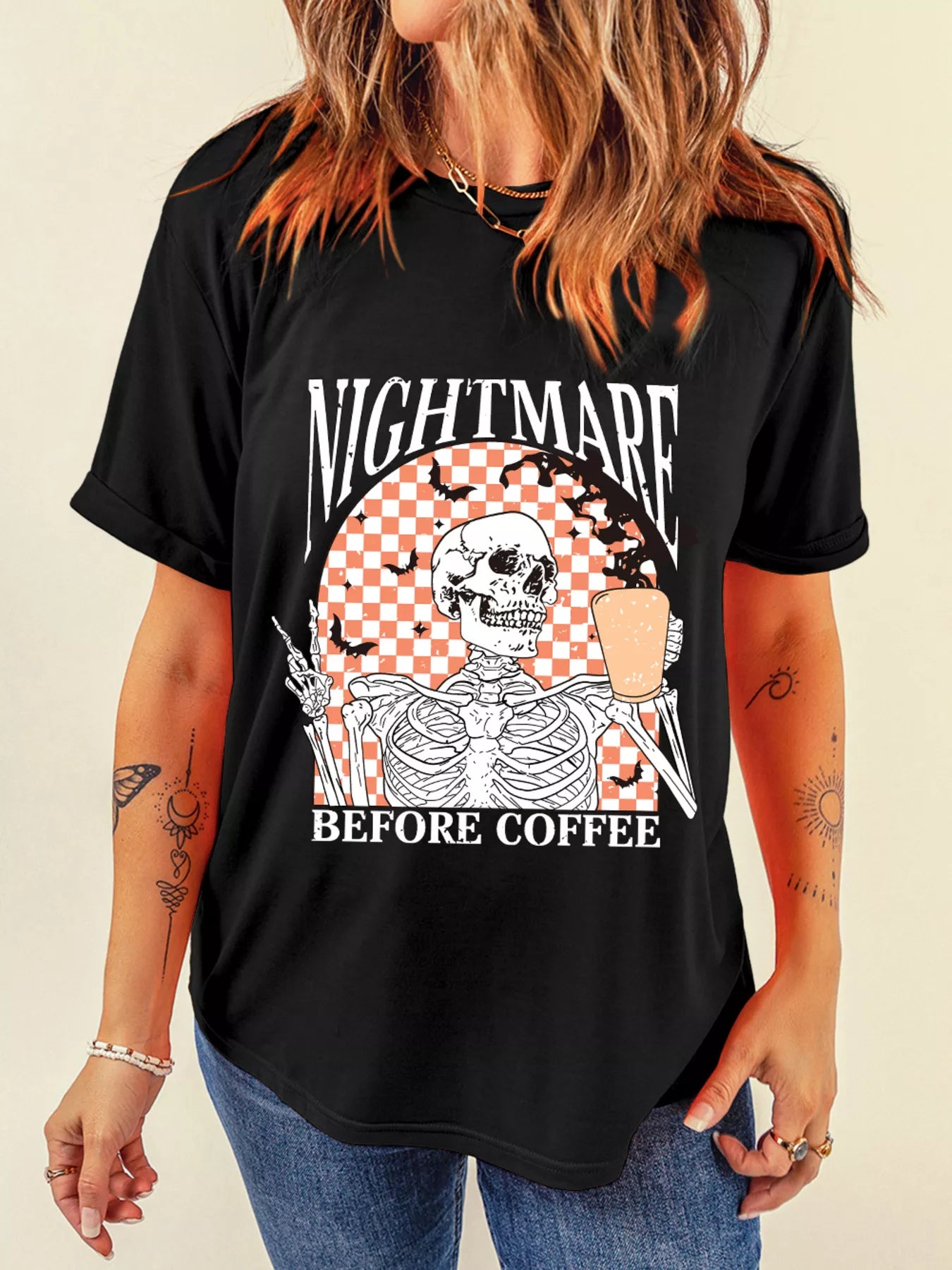 Black tee with a skeleton holding coffee and making a peace sign, with "NIGHTMARE BEFORE COFFEE" text.