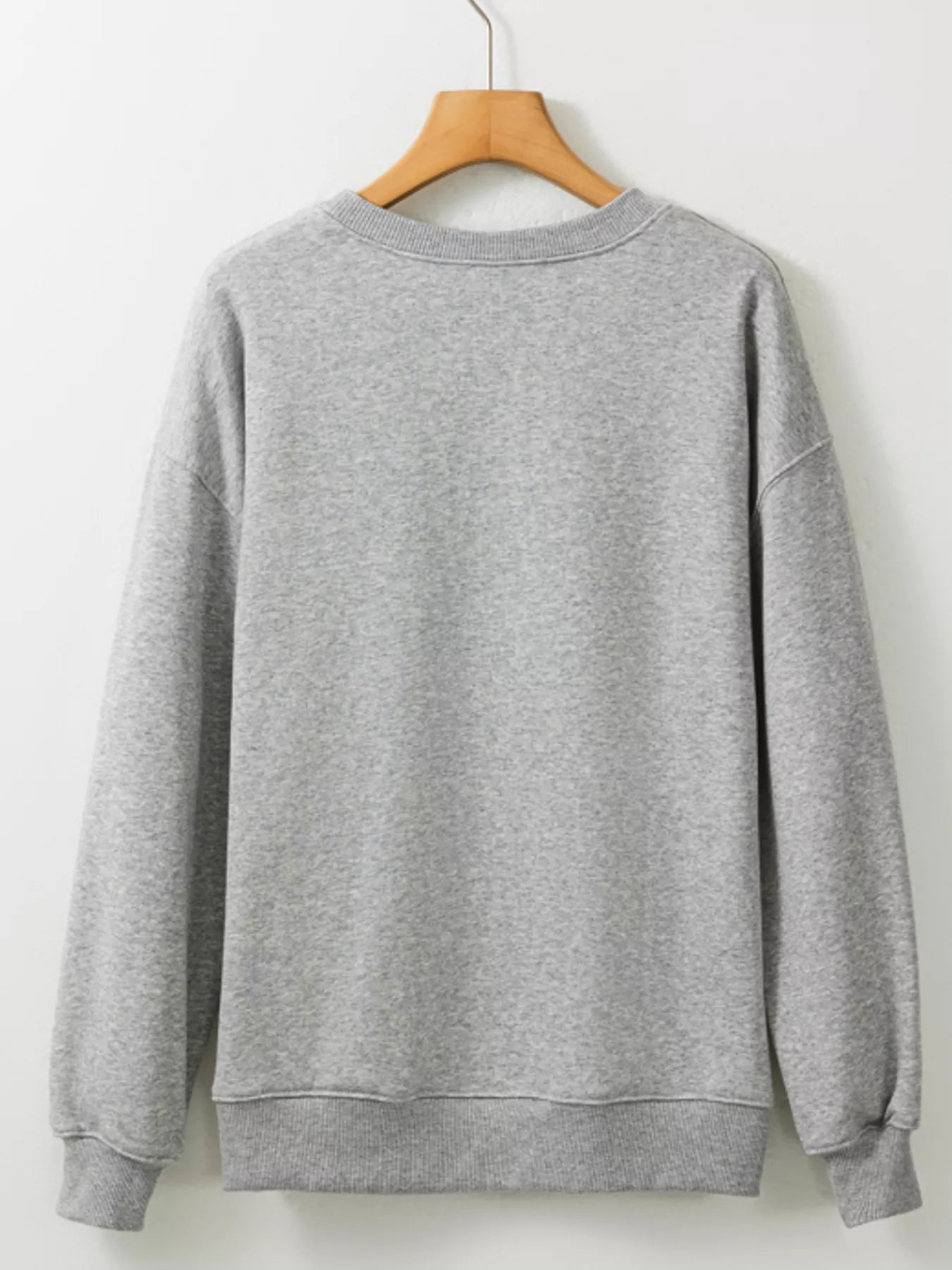 Gray round neck sweatshirt on a wooden hanger.