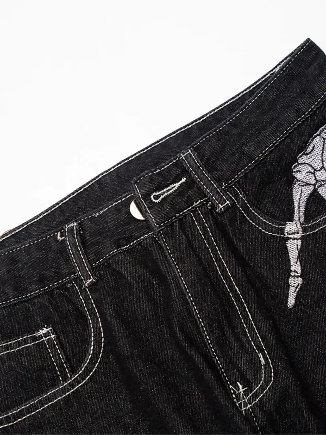 Men's black straight leg jeans with white skeleton embroidery.