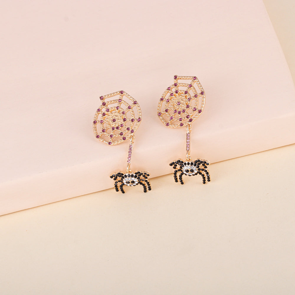 Gold-toned spiderweb and spider earrings with purple and clear rhinestones.