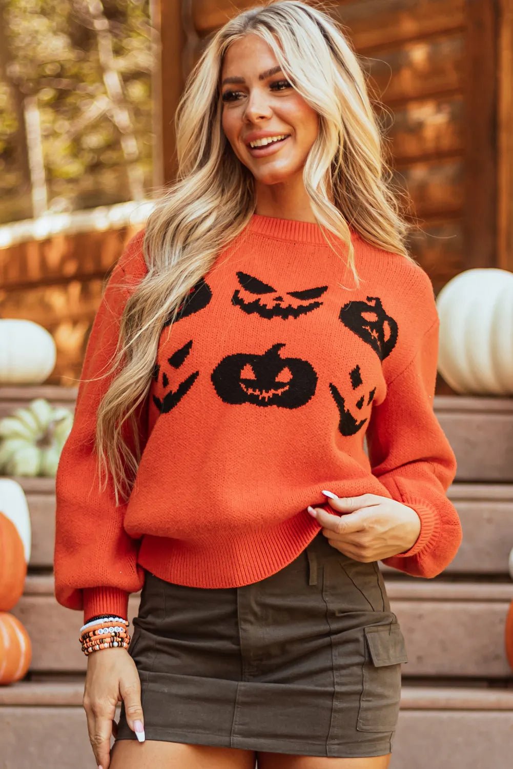 Orange round neck sweater with black pumpkin patterns.