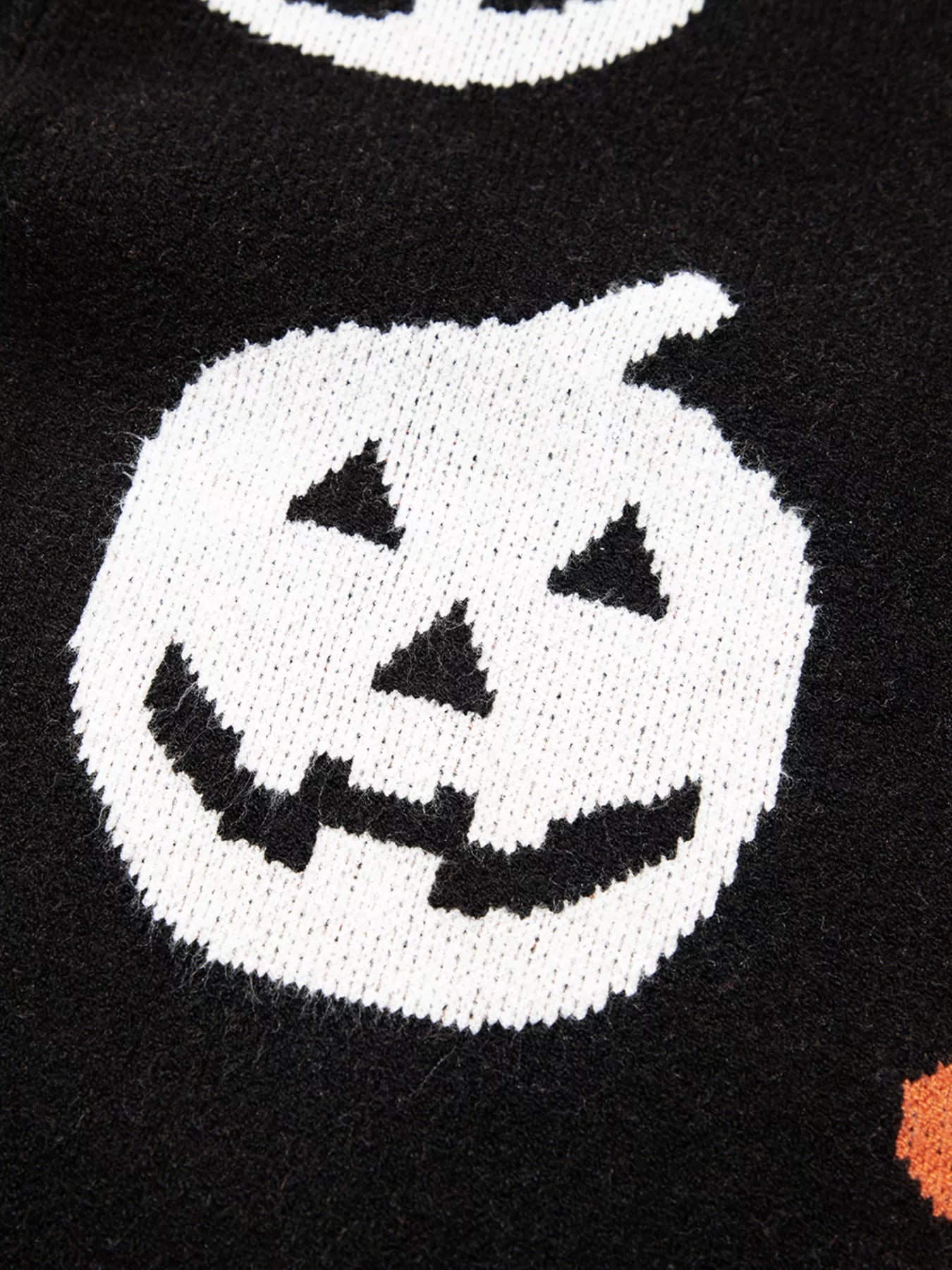 Black long-sleeve sweater with a white knitted jack-o'-lantern design.