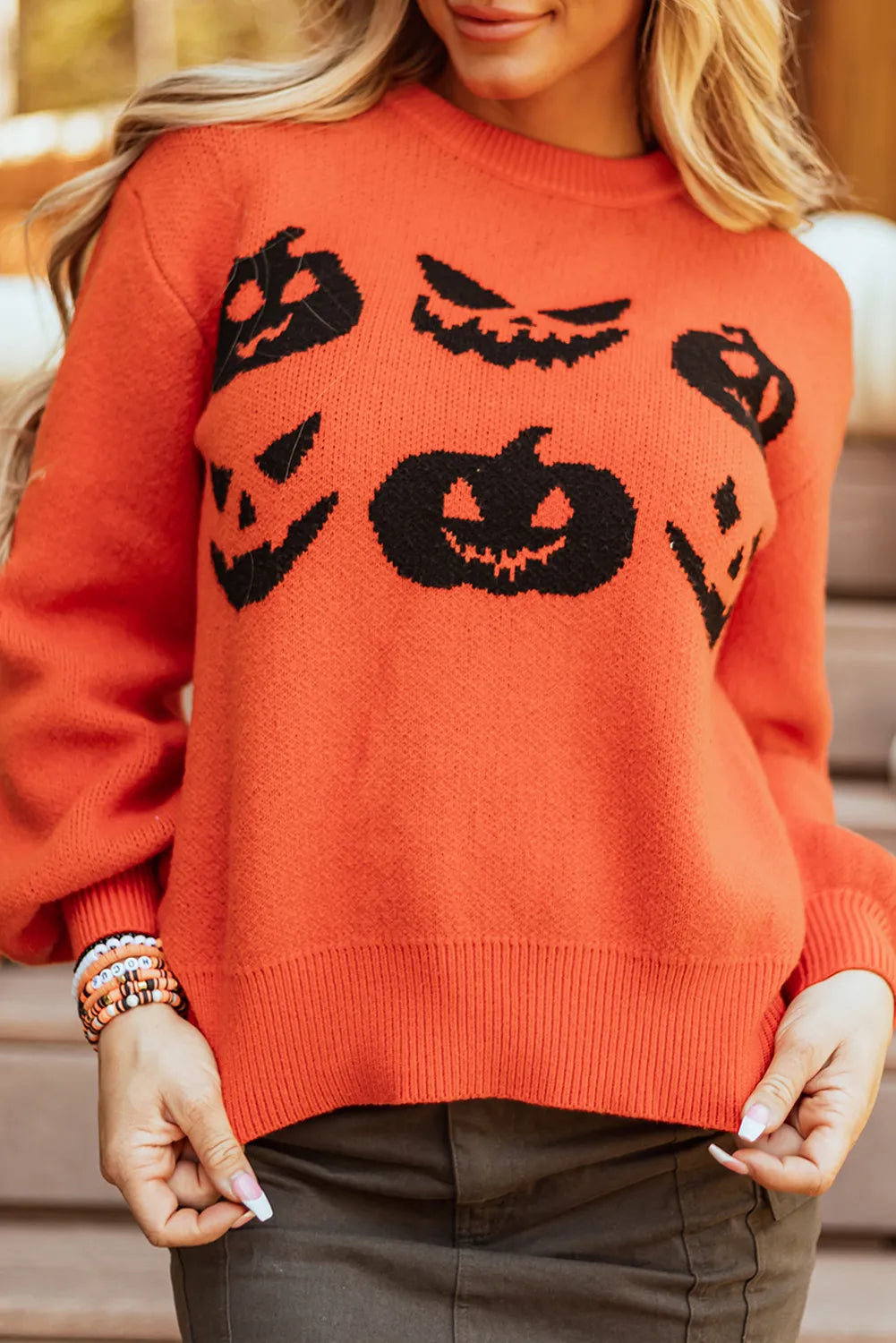 Orange round neck sweater with black pumpkin patterns.
