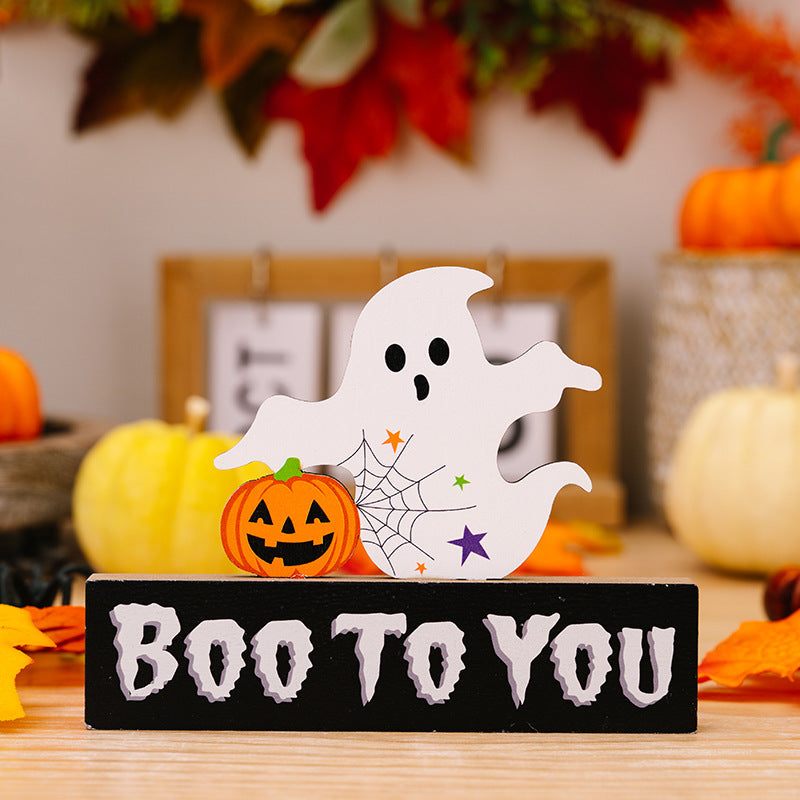 A ghost and pumpkin ornament on a black base that reads "Boo To You".