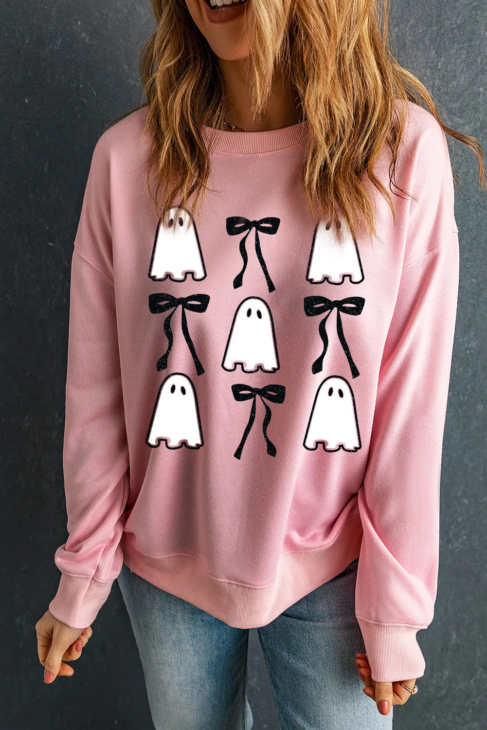 Pink long-sleeve sweatshirt with ghost and bow graphics.