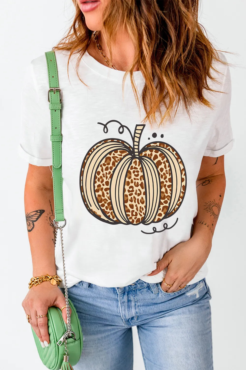 A woman wears a white short-sleeve t-shirt with a leopard print pumpkin design.