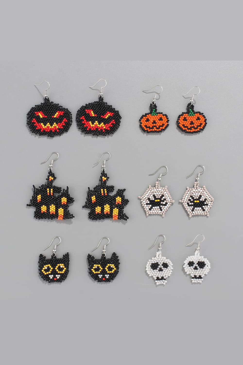 Six pairs of Halloween-themed beaded earrings are displayed on a gray background.