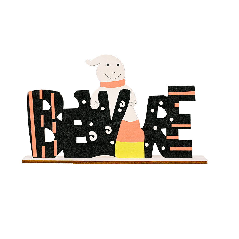 A wooden Halloween ornament spelling "BEWARE" with a ghost and candy corn.