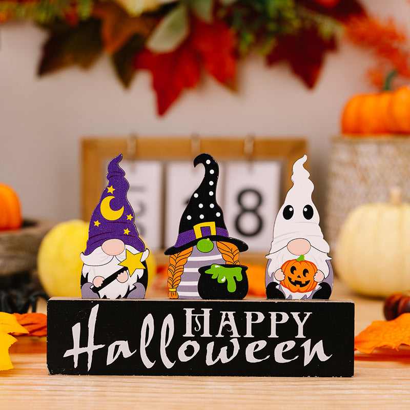 Three Halloween gnome ornaments on a black "Happy Halloween" sign.
