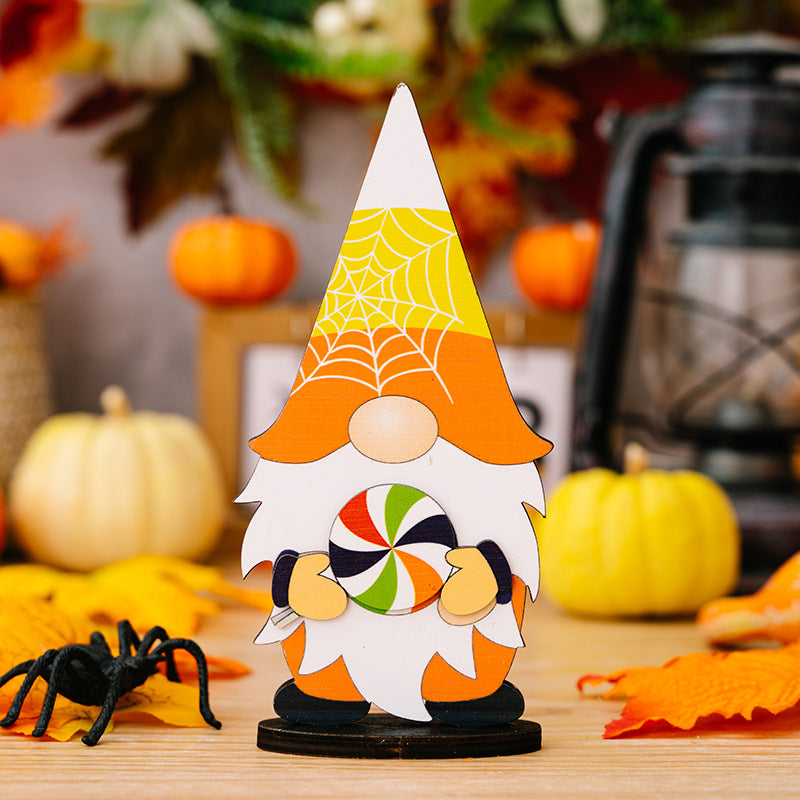 A Halloween gnome ornament with a candy corn hat and a colorful lollipop.