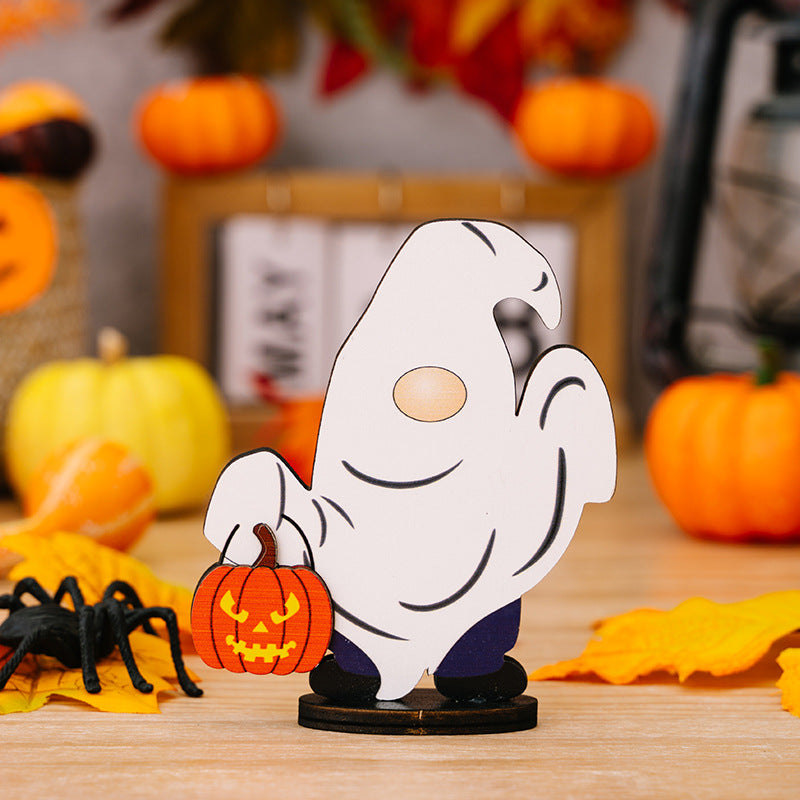 A ghost gnome ornament holding a pumpkin, surrounded by Halloween decorations.