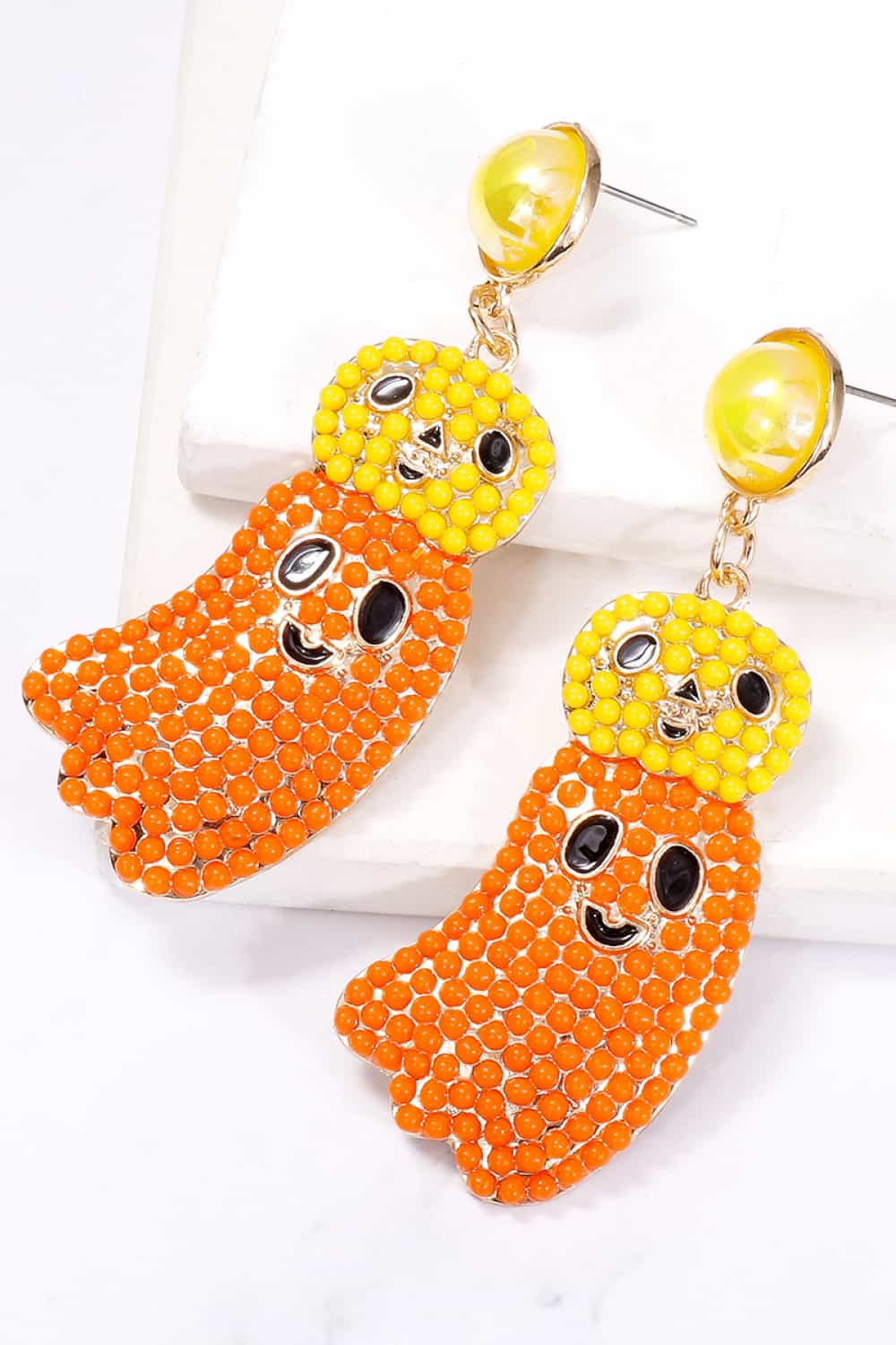 Two Halloween ghost-shaped dangle earrings with yellow and orange beads.