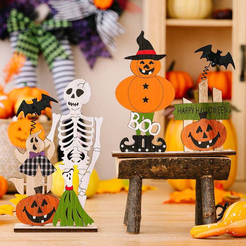 Two wooden Halloween ornaments, one with a skeleton and ghost, the other with pumpkins and a bat.