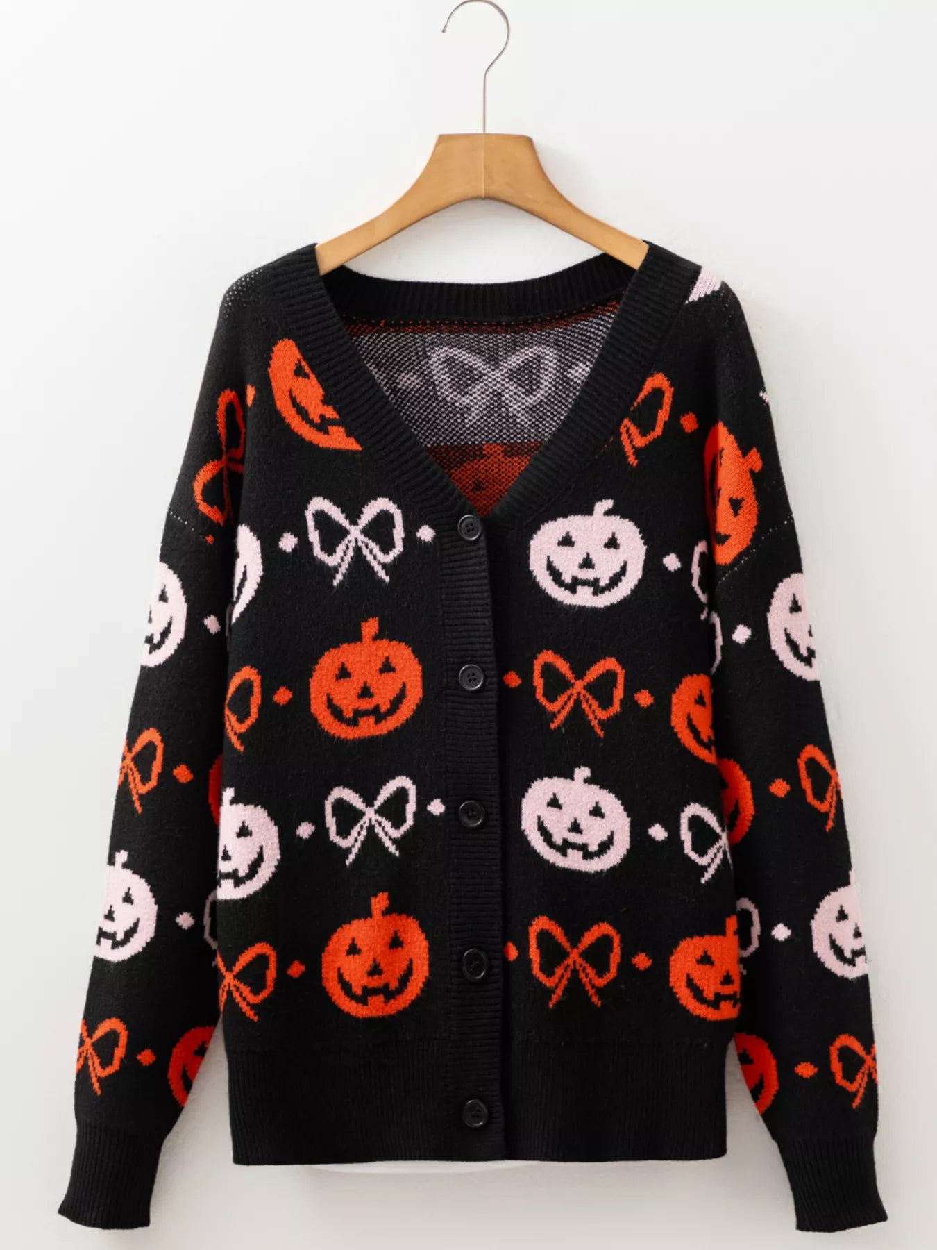 Black button-up cardigan with orange and pink Halloween pumpkin and bow patterns.