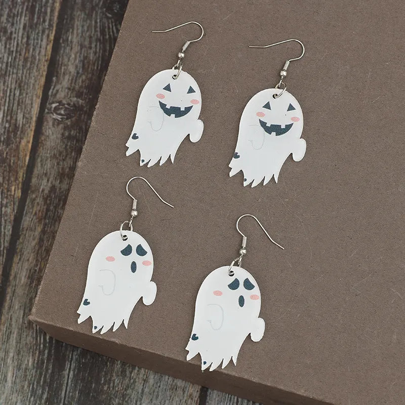 Four ghost-shaped dangle earrings, two with smiling faces and two with sad faces.