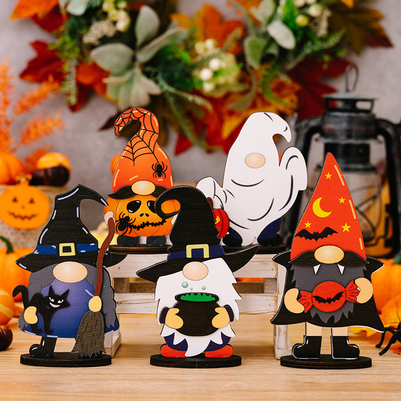 Six assorted Halloween gnome ornaments are displayed on a wooden surface.