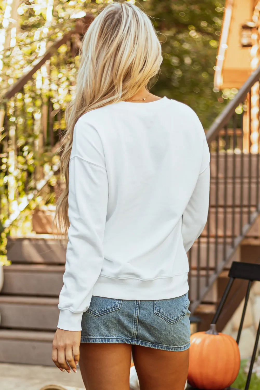 Pumpkin Graphic Long Sleeve Sweatshirt in white, worn with denim shorts.