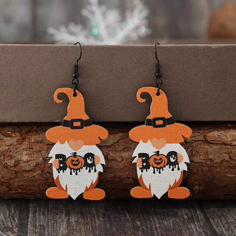 A pair of wooden Halloween gnome dangle earrings with orange hats and "BOO" with a pumpkin.