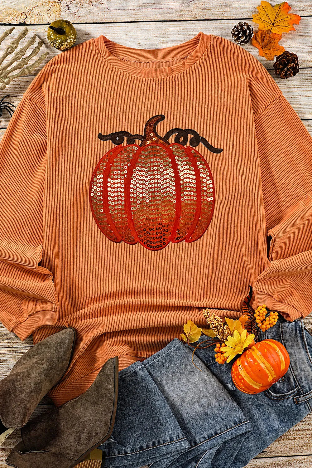Orange ribbed long-sleeve sweatshirt with a sequin pumpkin design.
