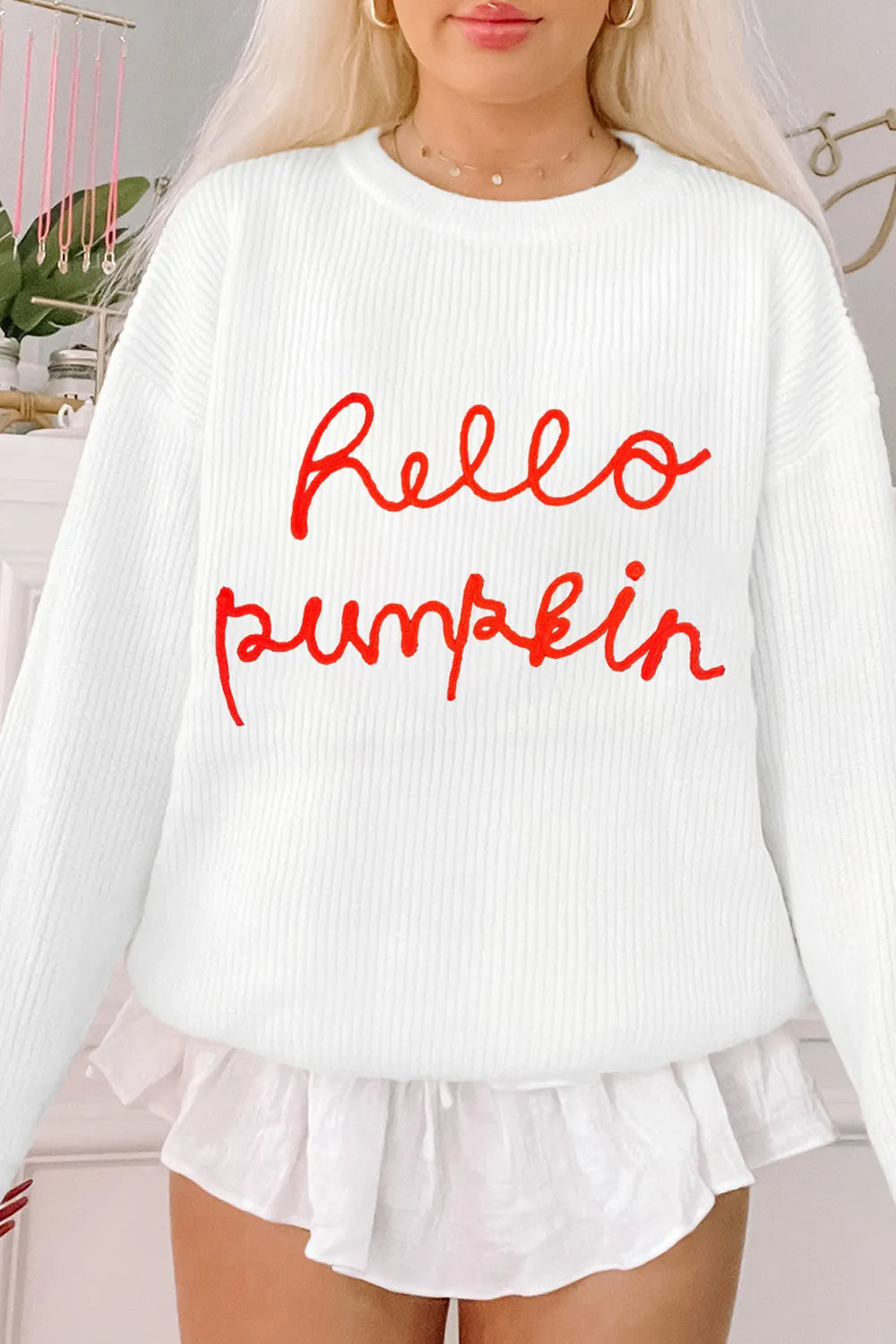 White long-sleeve sweater with "hello pumpkin" in red script.