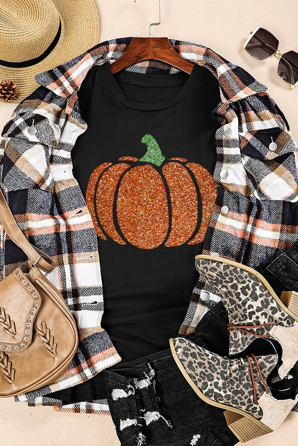 Black short-sleeve t-shirt with a glitter pumpkin design, styled with a plaid shirt.