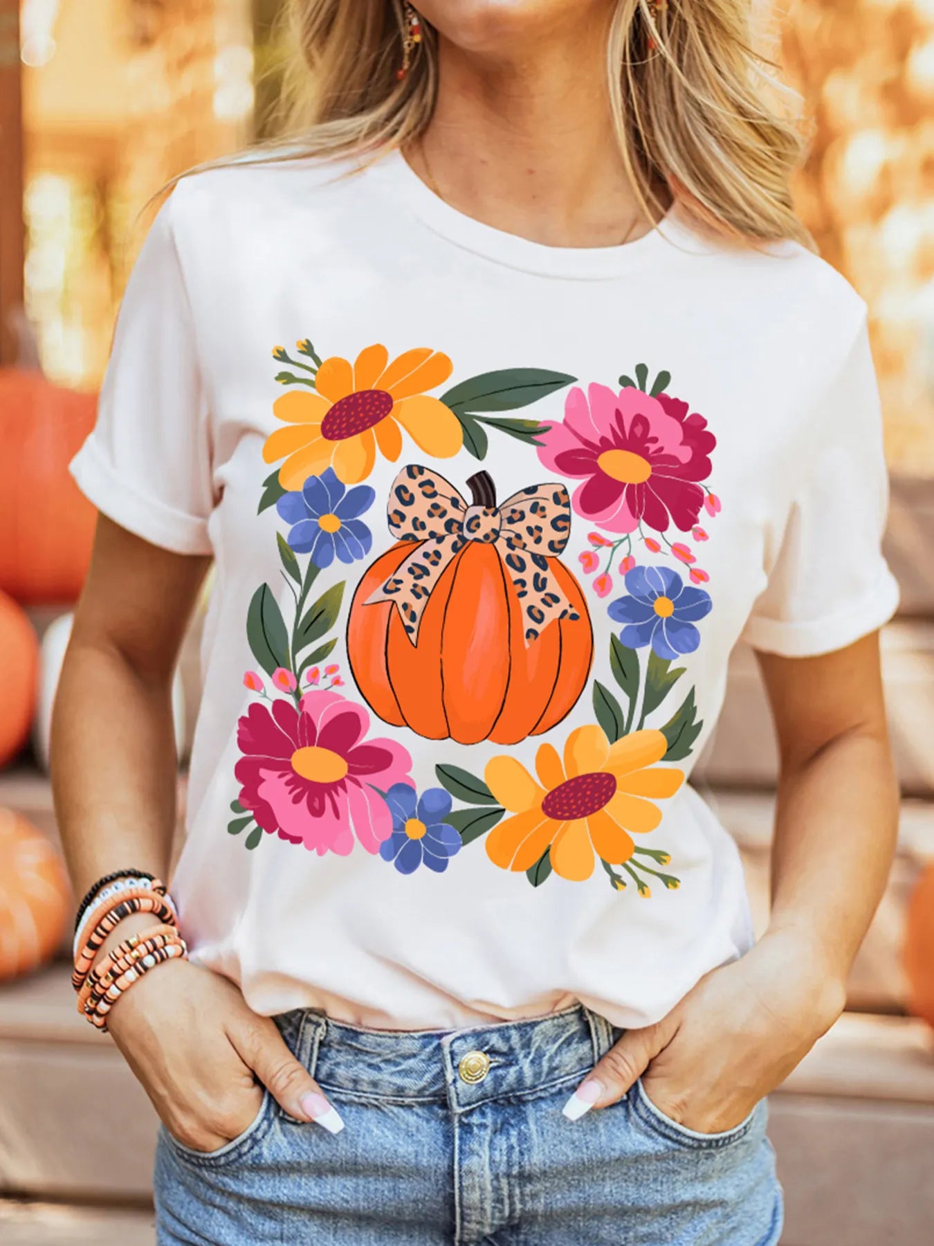 White round neck t-shirt with a pumpkin and floral graphic.