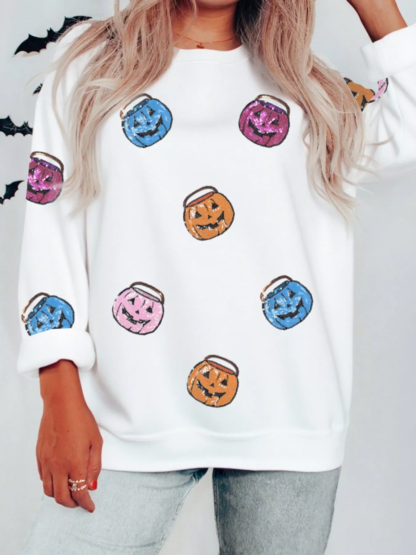 White sweatshirt with colorful sequin pumpkin lantern patches.