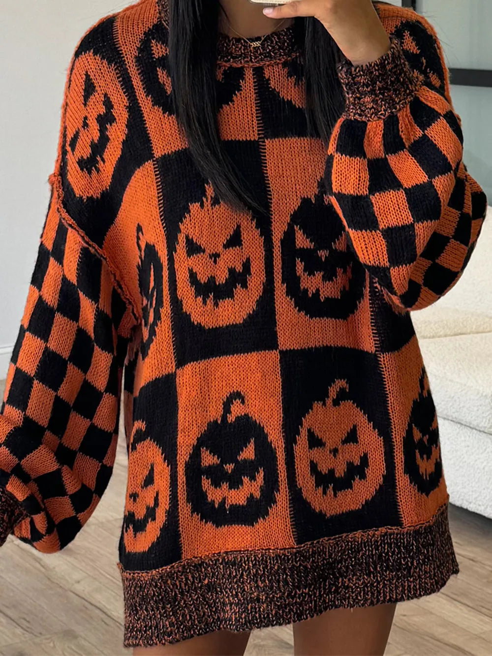 Orange and black pumpkin and checkerboard pattern long sleeve sweater.