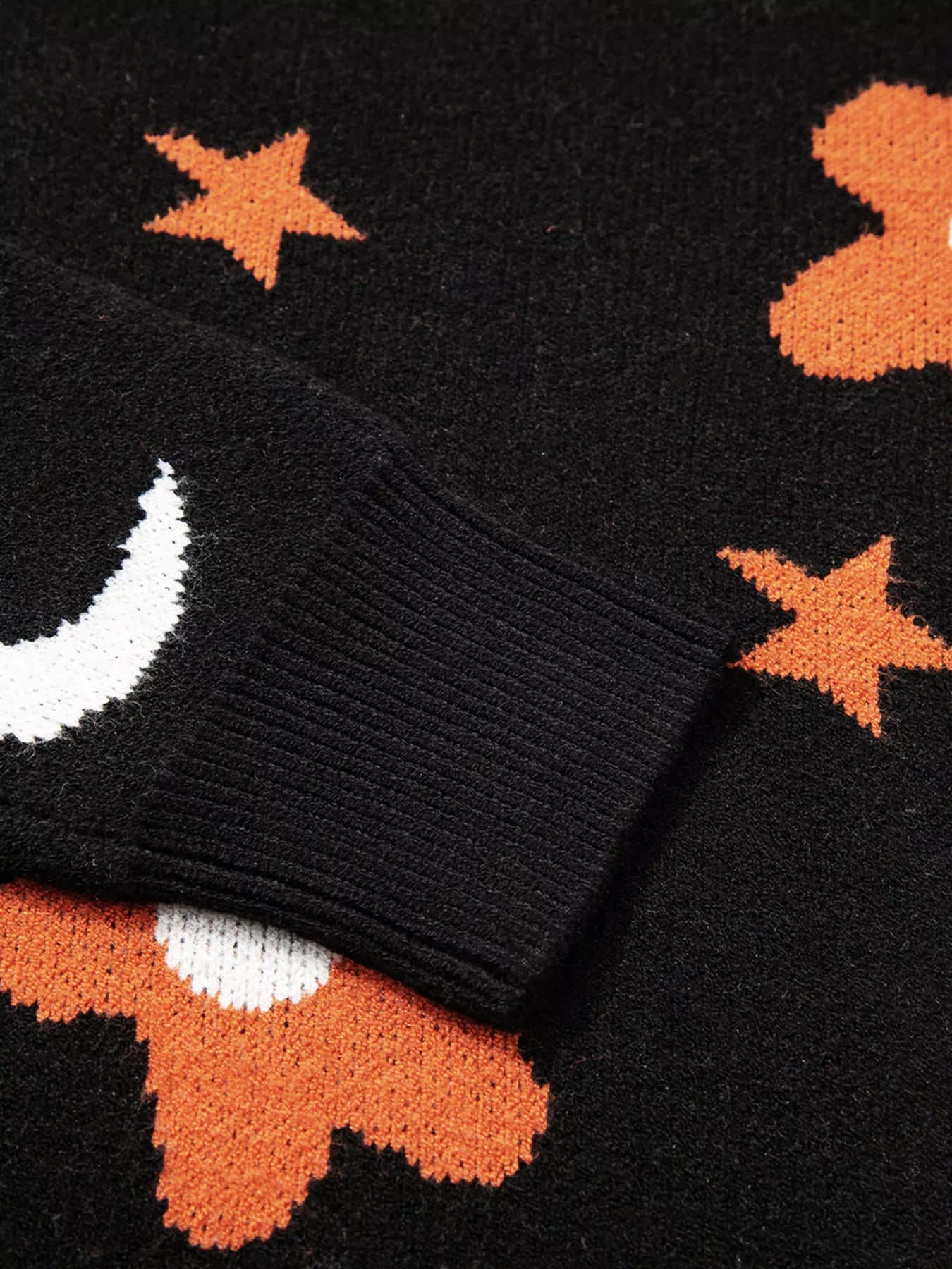 Black long-sleeve sweater with orange stars and a white crescent moon.