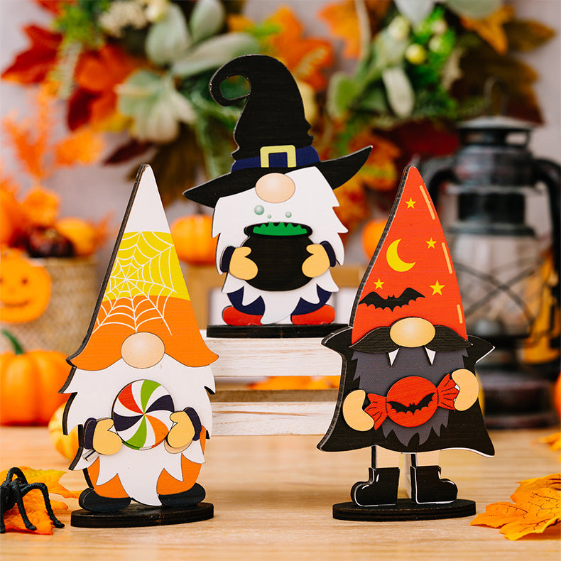 Three wooden Halloween gnome ornaments are displayed on a wooden surface.