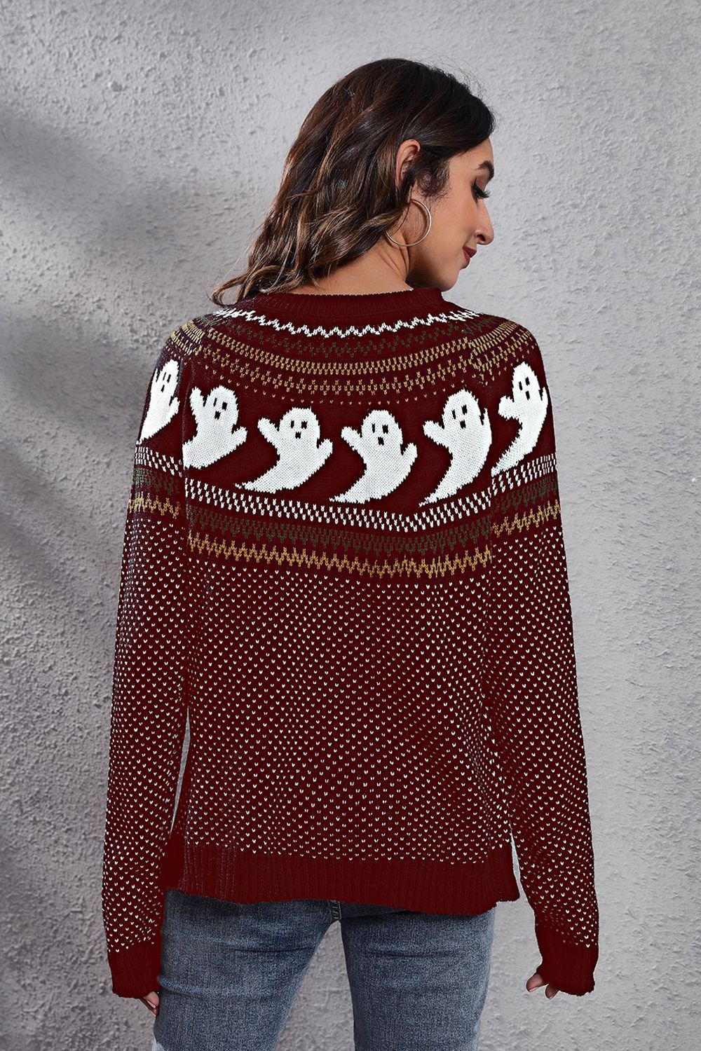 A woman models a maroon long-sleeve sweater with a ghost pattern.