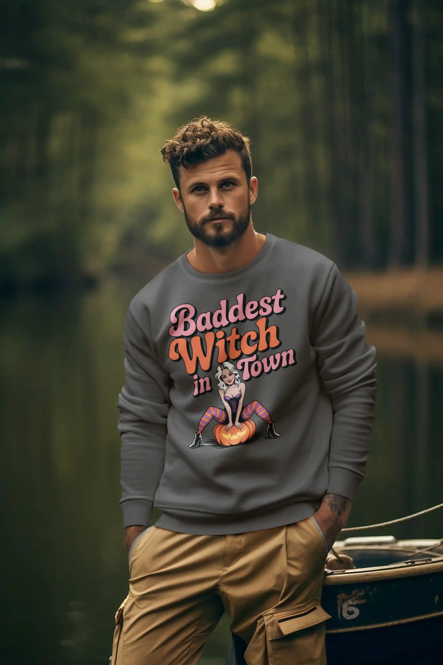 A man wears a dark gray sweatshirt with "Baddest Witch in Town" and a witch graphic.