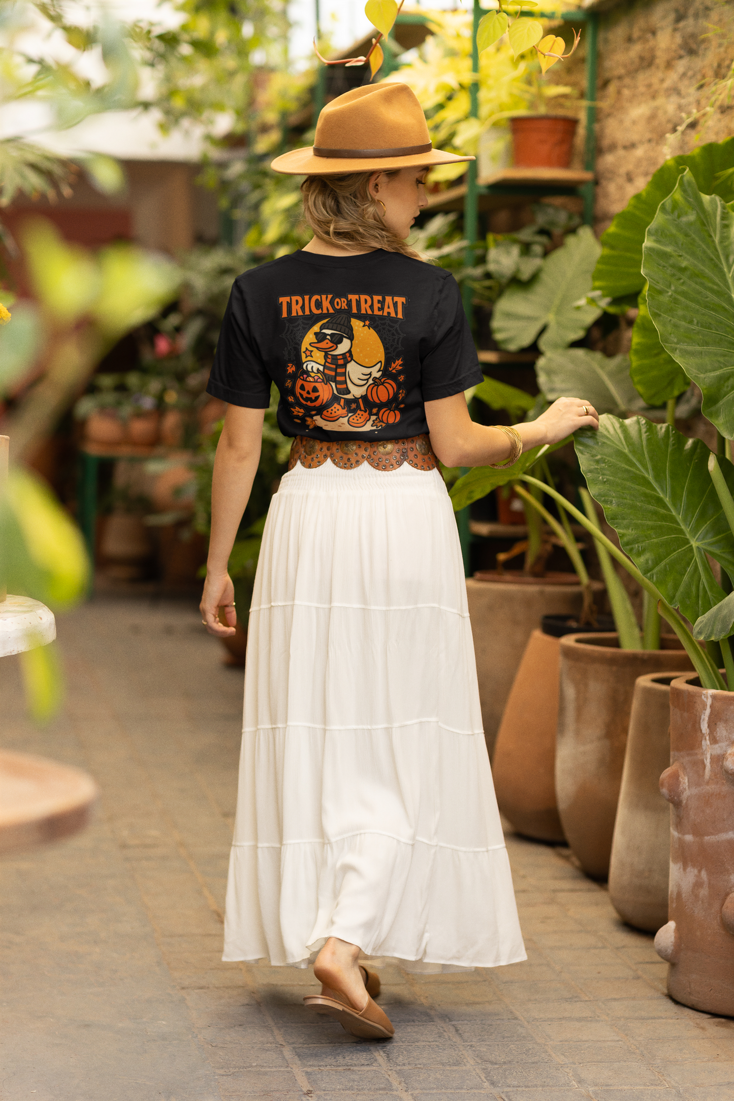 Black t-shirt with a "Trick or Treat" duck graphic, worn by a person from behind.