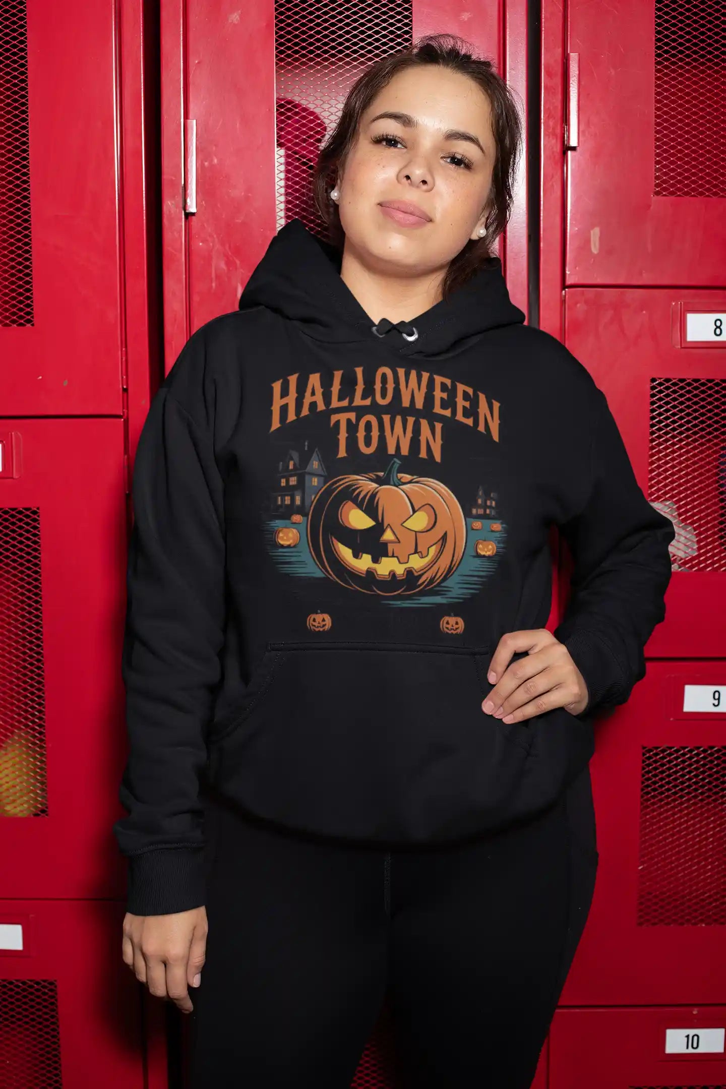 A woman wears a black Halloween Town hoodie with a vintage pumpkin graphic.