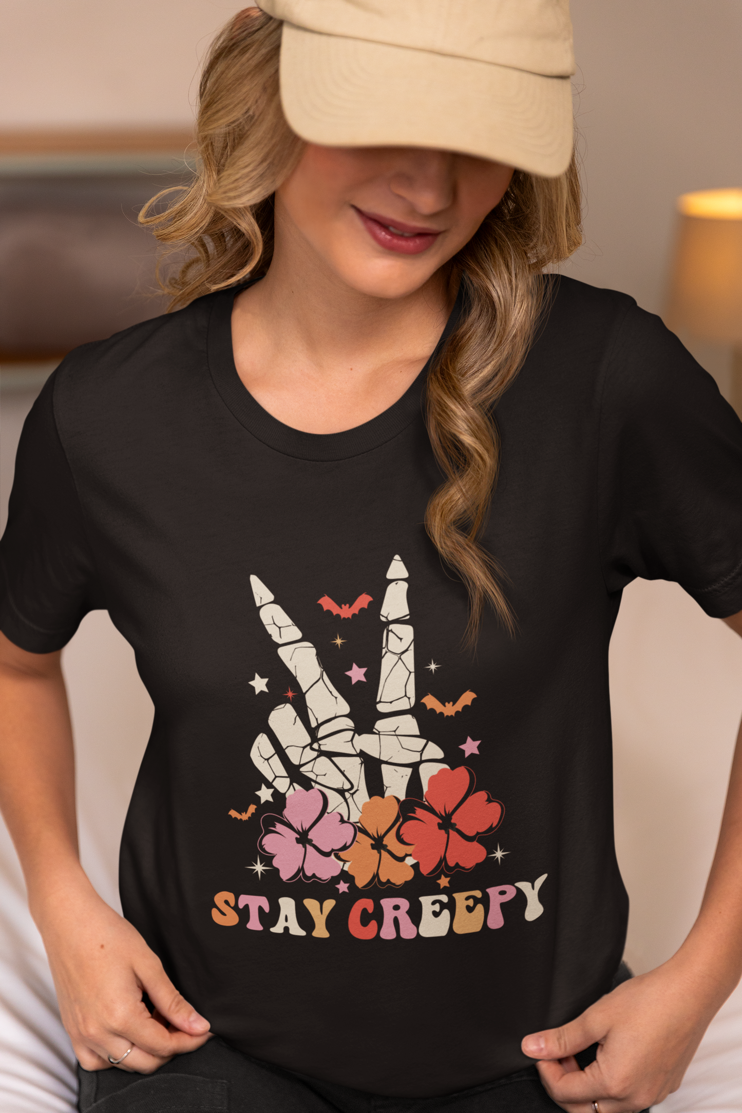 A woman wearing a black t-shirt with a skeleton peace sign and "Stay Creepy" text.