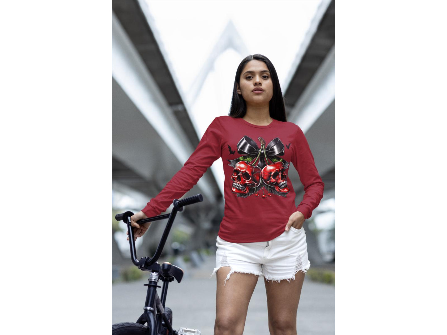 A woman wears a red long-sleeve shirt with a spooky cherry and bow design.