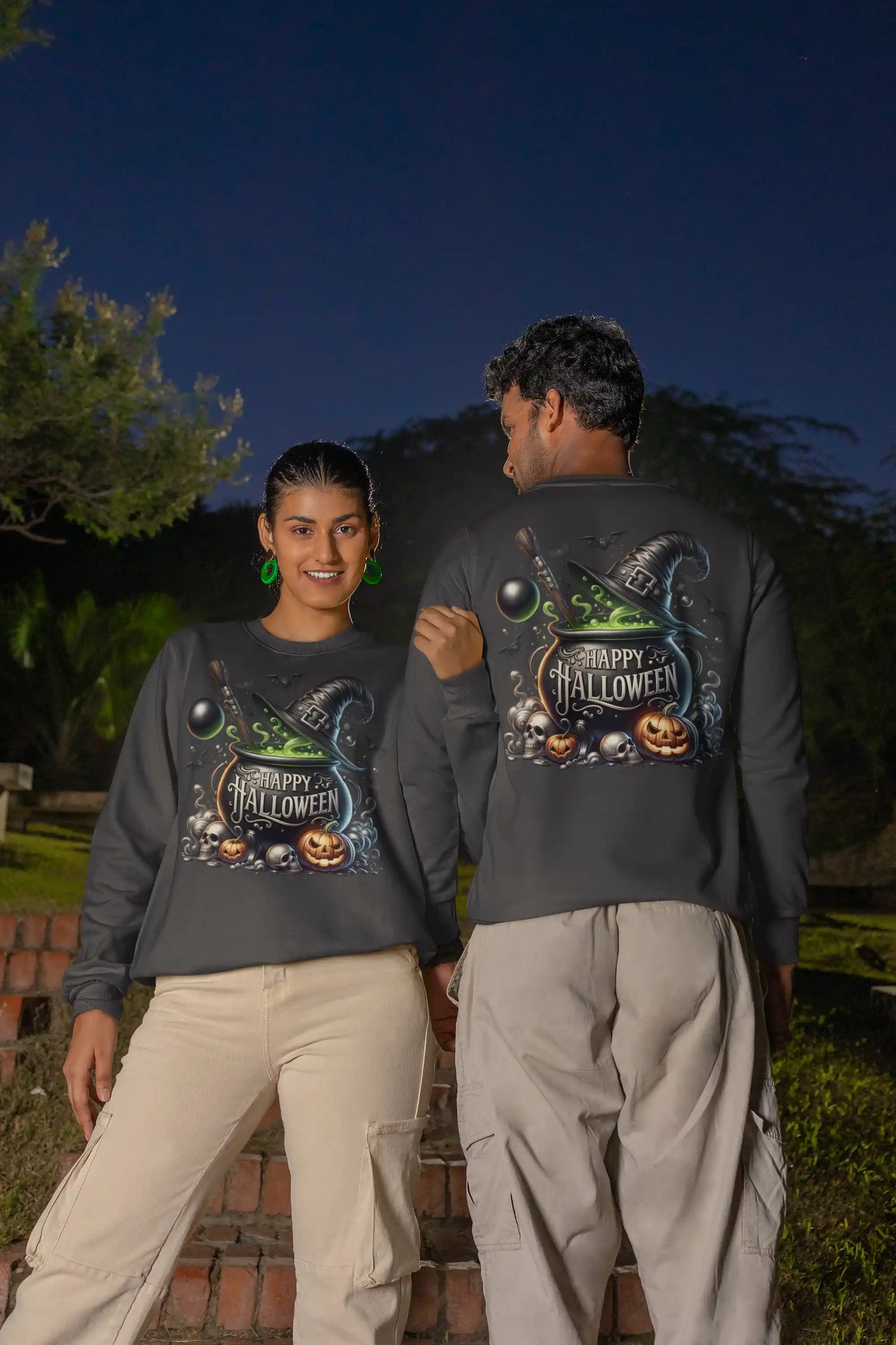 Two people wear dark gray long-sleeve sweatshirts with a Halloween graphic.