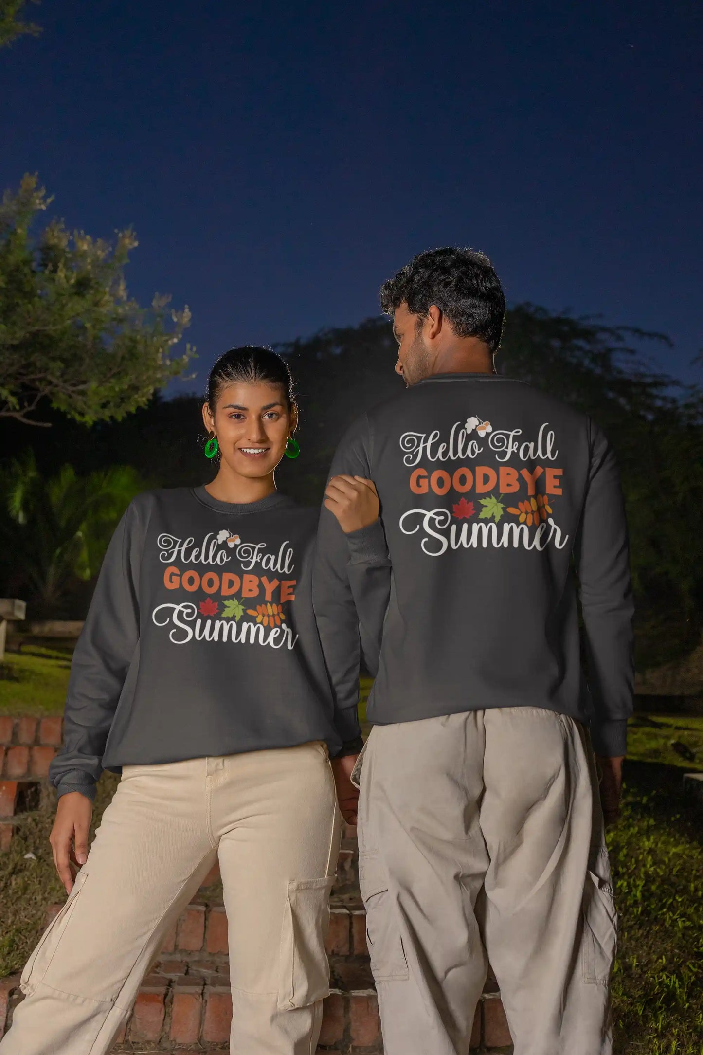 Two people wear matching dark gray "Hello Fall GOODBYE Summer" sweatshirts.