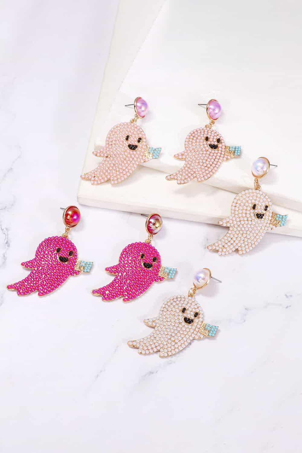 Six pairs of ghost-shaped dangle earrings with synthetic pearls in pink, fuchsia, and white.