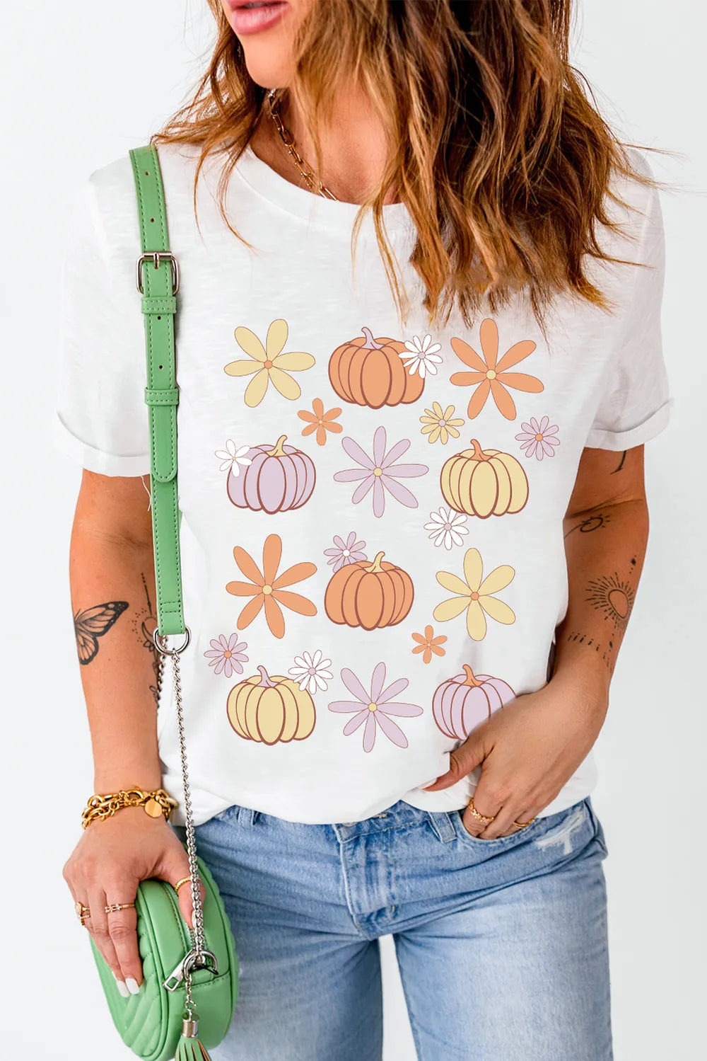 A woman wears a white short-sleeve t-shirt with a pumpkin and flower print.