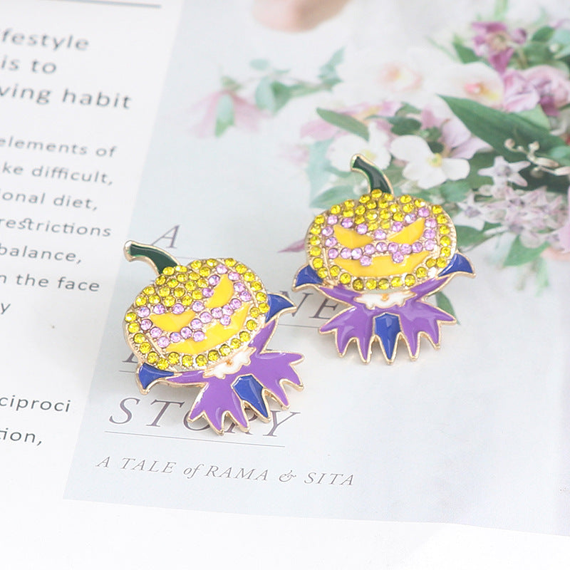 Two rhinestone alloy earrings shaped like demon pumpkins with purple and yellow accents.