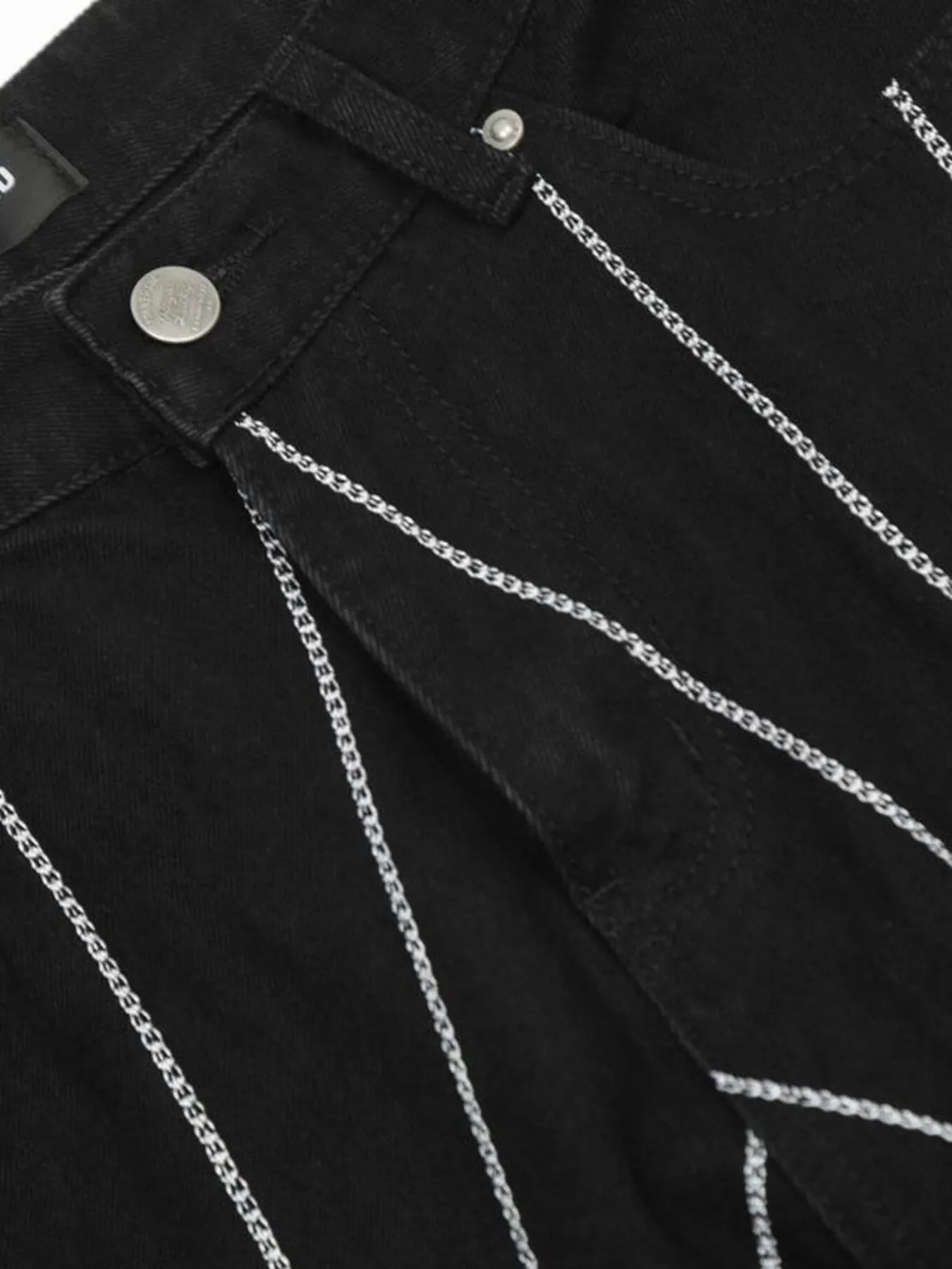 Black flared jeans with silver chain embroidery.