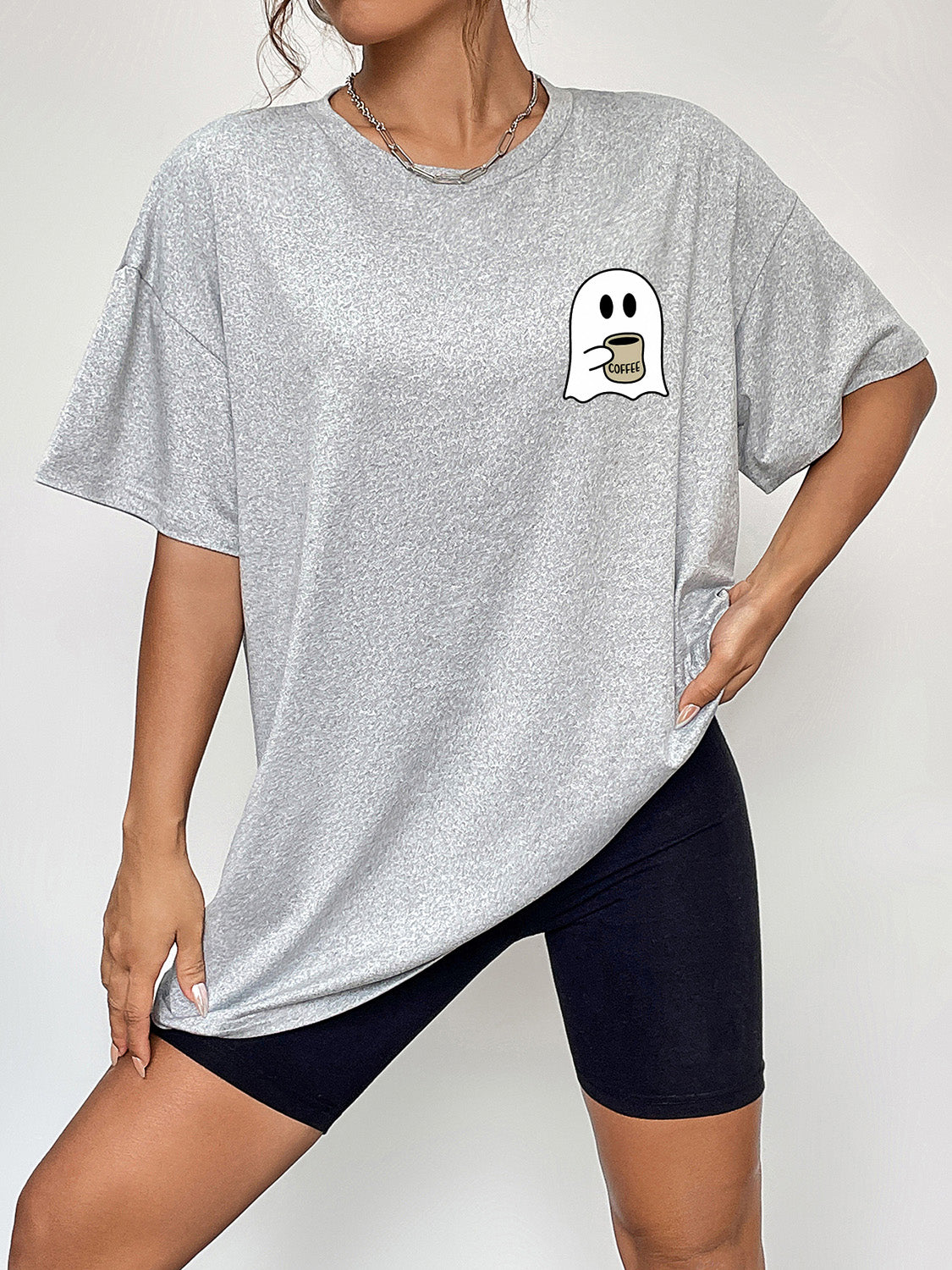 Round neck short sleeve ghost graphic t-shirt worn with black shorts.