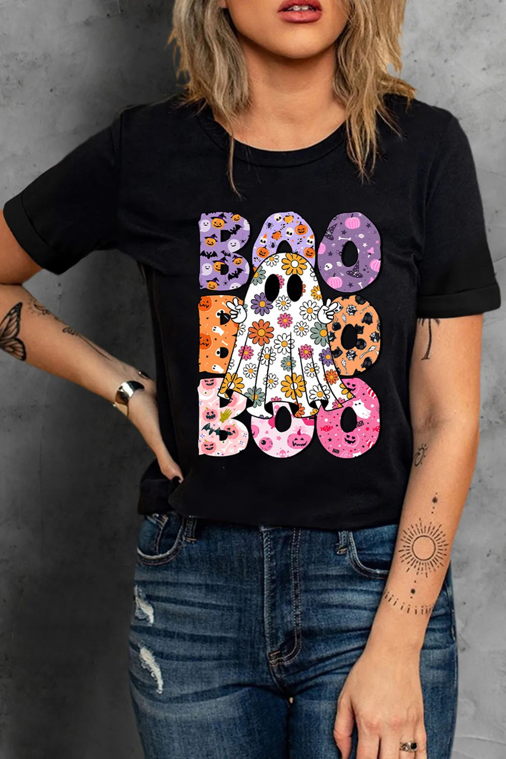 A woman wears a black short-sleeve t-shirt with a colorful "BOO" ghost graphic.