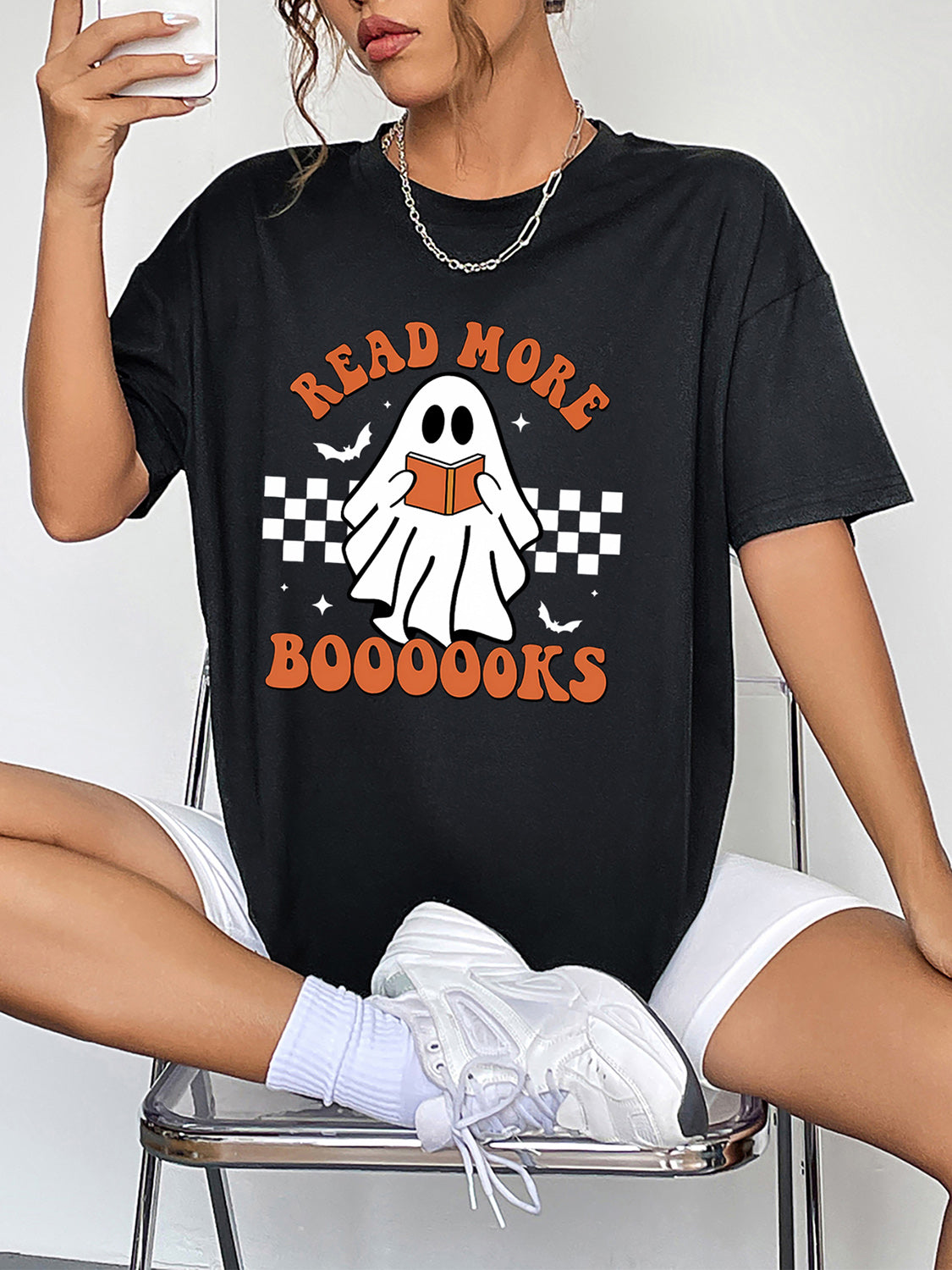 Black round neck t-shirt with a ghost graphic reading "Read More Boooooks".
